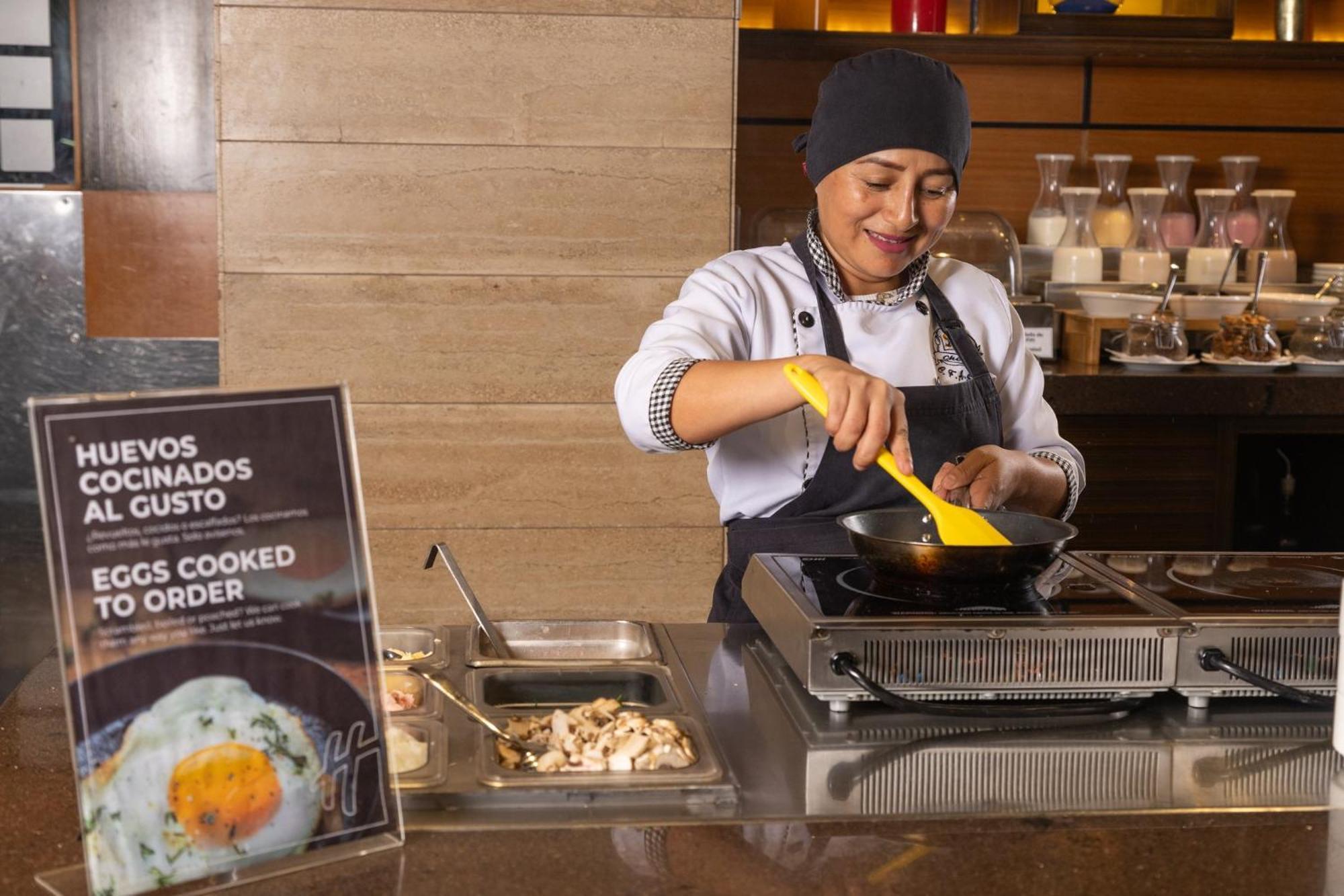 Holiday Inn Guayaquil Airport By Ihg Kültér fotó A woman cooking eggs